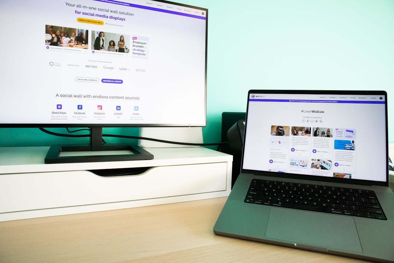 about-img Office desk workspace with a laptop and a monitor displaying a social media wall solution.