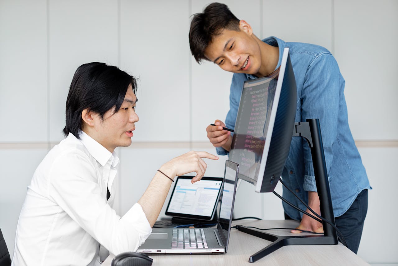 services-img Two Asian men collaborating on a project using computers in an office.